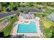 Aerial view of a community pool and clubhouse, complete with a playground, lounge chairs and ample green space at 1347 Eisenhower Nw Pl, Concord, NC 28027