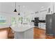 Modern kitchen with white cabinets, quartz countertops, stainless steel appliances, and hardwood floors at 1347 Eisenhower Nw Pl, Concord, NC 28027