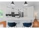 Modern kitchen with white cabinets, quartz countertops, stainless steel appliances, and hardwood floors at 1347 Eisenhower Nw Pl, Concord, NC 28027