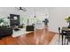 Open living room with fireplace, hardwood floors, and modern design flowing into kitchen and dining at 1347 Eisenhower Nw Pl, Concord, NC 28027