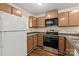 The kitchen features brown cabinets, a microwave, a stainless steel range, and a white refrigerator at 1606 Eagles Pl # J101, Rock Hill, SC 29732
