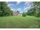 Expansive backyard with lush green grass and mature trees, offering a serene and private outdoor space at 16308 Poplar Tent Rd, Huntersville, NC 28078