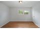 Bedroom featuring hardwood floors, base molding and large windows at 16308 Poplar Tent Rd, Huntersville, NC 28078