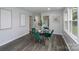 Stylish dining room featuring a glass-top table, emerald green chairs, and modern artwork at 16308 Poplar Tent Rd, Huntersville, NC 28078
