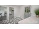 Hallway features starburst-patterned tile floor and door to outdoors with large panes of glass at 16308 Poplar Tent Rd, Huntersville, NC 28078