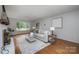 Sunlit living room featuring a cozy sofa, hardwood floors, and modern décor at 16308 Poplar Tent Rd, Huntersville, NC 28078