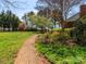 Brick walkway winds through a lush backyard with mature trees and a fenced perimeter at 17109 Cabarrus Rd, Midland, NC 28107