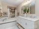 Bright bathroom featuring a soaking tub, double sink vanity with white cabinets and marble countertops at 17109 Cabarrus Rd, Midland, NC 28107