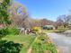 Charming home exterior with lush green lawn, gravel driveway, shed, and mature trees at 17109 Cabarrus Rd, Midland, NC 28107