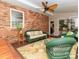 Relaxing sunroom with brick accent wall, wicker furniture, and natural light at 17109 Cabarrus Rd, Midland, NC 28107