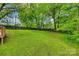 Lush green backyard with mature trees and a privacy fence, great for outdoor enjoyment at 210 Knox St, Clover, SC 29710