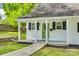 Charming home with a well-manicured lawn, covered front porch and a green front door at 210 Knox St, Clover, SC 29710