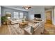 Sunlit living room with neutral colors, wood floors, ceiling fan, and area rug at 210 Knox St, Clover, SC 29710