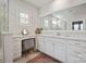 Bright bathroom features a makeup vanity, neutral tile floor, and large mirror at 22014 Finworthy Ln, Huntersville, NC 28078