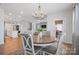 Open-concept dining area features hardwood floors, a round table, and a modern chandelier at 22014 Finworthy Ln, Huntersville, NC 28078