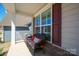 Inviting front porch with a cozy bench, decorative pillows, and stylish shutters at 22014 Finworthy Ln, Huntersville, NC 28078