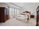 Spacious main bedroom with a seating area, tray ceiling, and large windows with curtains at 22014 Finworthy Ln, Huntersville, NC 28078