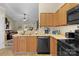 Well-lit kitchen with wooden cabinets, black appliances and a double sink offers a practical cooking space at 228 Grayland Rd, Mooresville, NC 28115