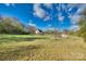 Spacious backyard with green grass, scattered trees, and a house in the distance at 2331 Gill Jordan Rd, Chester, SC 29706