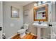 Charming half bath with a pedestal sink, framed mirror and hardwood floors at 2331 Gill Jordan Rd, Chester, SC 29706