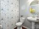 Modern bathroom with geometric wallpaper, round mirror, and a pedestal sink at 246 Sweet Briar Dr, Fort Mill, SC 29707