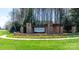 A welcoming stone entrance to The Retreat at Rayfield is beautifully landscaped with green grass and yellow flowers at 246 Sweet Briar Dr, Fort Mill, SC 29707