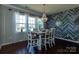 Bright dining room features a wood accent wall, modern chandelier, and table with six chairs at 246 Sweet Briar Dr, Fort Mill, SC 29707