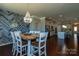 Open concept dining room with stylish chandelier, wood accent wall, and flows into the kitchen at 246 Sweet Briar Dr, Fort Mill, SC 29707