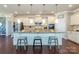Spacious kitchen features an island with seating, white cabinets, granite countertops, and stainless steel appliances at 246 Sweet Briar Dr, Fort Mill, SC 29707