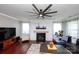 Comfortable living room featuring a brick fireplace, ceiling fan, and ample natural light at 246 Sweet Briar Dr, Fort Mill, SC 29707