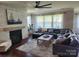 Bright living room with a stone fireplace, modern ceiling fan, and comfortable seating at 246 Sweet Briar Dr, Fort Mill, SC 29707