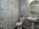 Modern powder room featuring geometric wallpaper, a pedestal sink, and a round mirror at 246 Sweet Briar Dr, Fort Mill, SC 29707