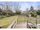 Large grassy backyard with a shed is seen from the wooden deck with railing at 2922 Dunlavin Way, Charlotte, NC 28205