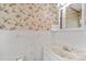 Small bathroom featuring classic fixtures, floral wallpaper, and neutral-toned ceramic tile at 2922 Dunlavin Way, Charlotte, NC 28205