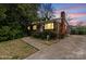 Charming single-story brick home featuring a well-manicured lawn and a concrete driveway at dusk at 2922 Dunlavin Way, Charlotte, NC 28205