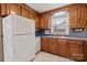 Traditional kitchen with wood cabinets, white appliances, and double-bowl stainless sink under a window at 2922 Dunlavin Way, Charlotte, NC 28205