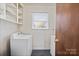 Functional laundry room featuring a stacked washer and dryer and a window providing natural light at 2922 Dunlavin Way, Charlotte, NC 28205