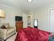 Inviting bedroom featuring a red bedspread, a bedside table with a lamp, and a cozy armchair at 464 Willetta Nw Pl, Concord, NC 28027