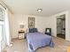 Cozy bedroom with a blue quilted bedspread, a bedside table with a lamp, and a bathroom ensuite at 464 Willetta Nw Pl, Concord, NC 28027