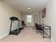 Versatile bonus room with carpet flooring, a treadmill, desk and neutral decor at 464 Willetta Nw Pl, Concord, NC 28027