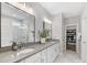 Bathroom featuring a double sink vanity with white cabinets, gray countertops, and a glimpse of the walk-in closet at 5013 Watercrest Trl, Belmont, NC 28012