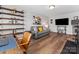 Bonus room featuring a gray couch, a large TV, a desk, an exercise bike, and vinyl floors at 5013 Watercrest Trl, Belmont, NC 28012