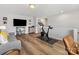 Bonus room featuring a gray couch, vinyl floors, a large TV, an exercise bike, a desk, and gray walls at 5013 Watercrest Trl, Belmont, NC 28012