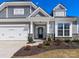 Home exterior with a 2-car garage, black front door, stone accents, and fresh landscaping at 5013 Watercrest Trl, Belmont, NC 28012