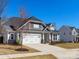 Charming home featuring a two-car garage, gray siding, and manicured lawn at 5013 Watercrest Trl, Belmont, NC 28012