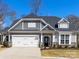 Charming home featuring a white two-car garage, gray siding, and a well-manicured lawn on a sunny day at 5013 Watercrest Trl, Belmont, NC 28012