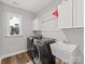 Laundry room with gray front load washer/dryer, white sink, and storage cabinets at 5013 Watercrest Trl, Belmont, NC 28012