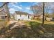 Home exterior featuring a grassy backyard, a driveway, and mature trees at 502 Crawford St, Shelby, NC 28150