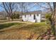Home exterior featuring a grassy backyard, a driveway, and mature trees at 502 Crawford St, Shelby, NC 28150