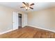 Bright bedroom featuring hardwood floors, a ceiling fan, and a closet with ample storage space at 502 Crawford St, Shelby, NC 28150